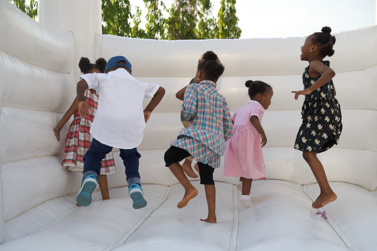 service-02 Happy kids jumping on a white bouncy castle, enjoying a sunny day outdoors.